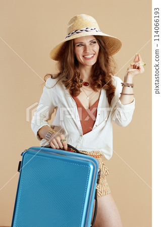 smiling female in blouse and shorts finger snapping on beige 114066193