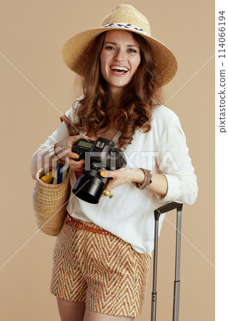 happy stylish woman in blouse and shorts on beige 114066194