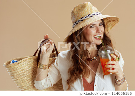 smiling elegant female in blouse and shorts on beige 114066196