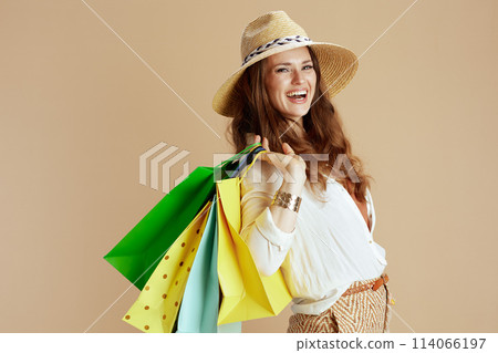 smiling stylish woman in blouse and shorts isolated on beige smiling stylish woman in blouse and shorts isolated on beige 114066197