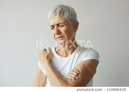 Senior woman with shoulder, upper arm pain. Human body health problem banner. Elderly female enduring awful ache. Upset lady with muscle, nerve pain symptom holding hand on painful zone injured point 114066426