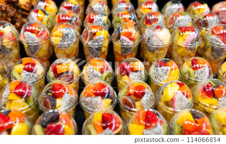 Fruit Salad arranged in plastic cups on a market. Cut and ready fruit ready to sell in market. Convenience, healthy lifestyle. Strawberries, kiwi, melon, pineapple, figs, dragon in a plastic glass. Fruit Salad arranged in plastic cups on a market. Cut and ready fruit ready to sell in market. Convenience, healthy lifestyle. Strawberries, kiwi, melon, pineapple, figs, dragon in a plastic glass. 114066854