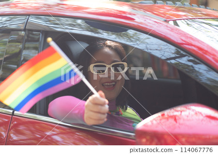 Hand holding a pride flag out the car window Hand holding a pride flag out the car window 114067776