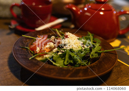 salad with fresh vegetables, greens and brynza cheese on a plate 114068060