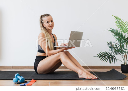 Young woman balancing work and fitness at home Young woman balancing work and fitness at home 114068581