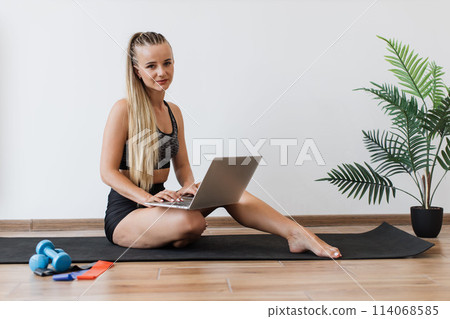Young woman balancing work and fitness at home 114068585