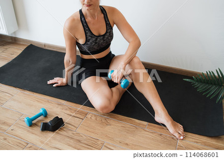 Fitness enthusiast relaxing after a workout in a serene home space 114068601