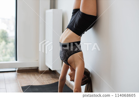 Young woman practicing yoga in a modern room Young woman practicing yoga in a modern room 114068605