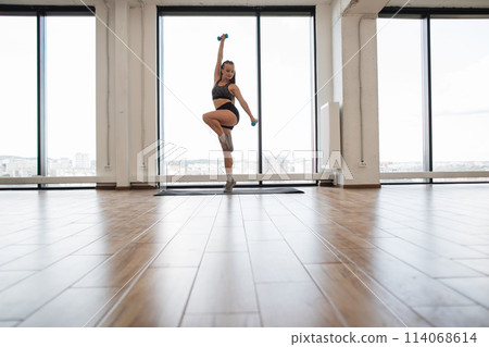 Fitness Enthusiast Exercising Balance and Strength in a Bright Studio Fitness Enthusiast Exercising Balance and Strength in a Bright Studio 114068614