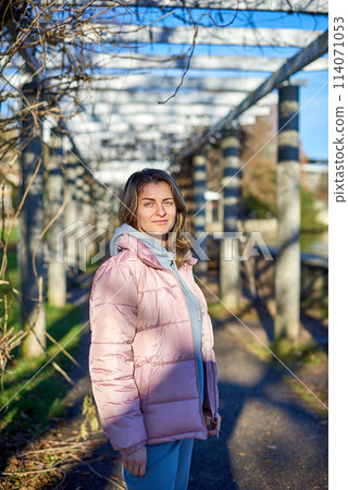 Winter Fun in Bitigheim-Bissingen: Beautiful Girl in Pink Jacket Amidst Half-Timbered Charm. a lovely girl in a pink winter jacket standing in the archway of the historic town of Bitigheim-Bissingen 114071053