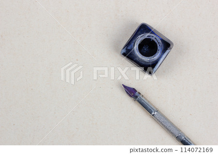 Vintage dip pen and inkwell on paper background Vintage dip pen and inkwell on paper background 114072169