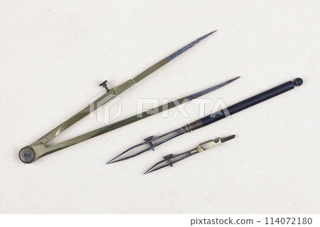 Vintage retro ruling pen with vintage bronze dividers calipers on paper 114072180