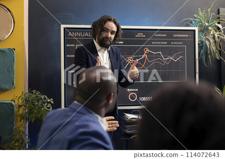 Accounting analysts examine sales trends and market needs to ensure success, looking into infographics in executive conference. Financial department group allocating capital funds. Accounting analysts examine sales trends and market needs to ensure success, looking into infographics in executive conference. Financial department group allocating capital funds. 114072643