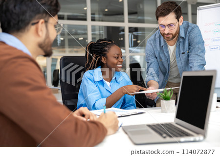 Group of coworkers with laptop having meeting in office Group of coworkers with laptop having meeting in office 114072877