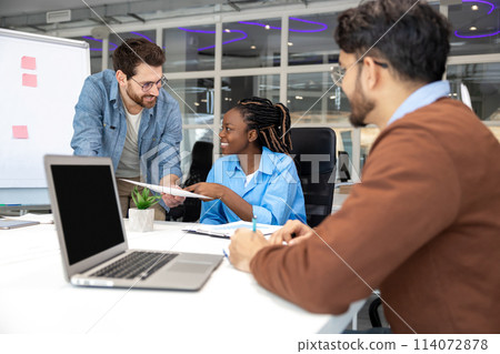 Group of coworkers with laptop having meeting in office Group of coworkers with laptop having meeting in office 114072878