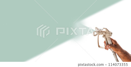 Professional Spray Painter Holding Spray Gun Spraying Teal Over White Surface. Professional Spray Painter Holding Spray Gun Spraying Teal Over White Surface. 114073355