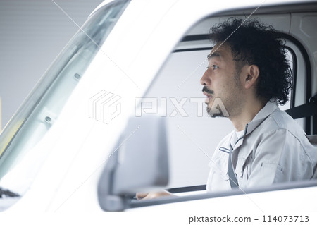 A middle-aged man in work clothes driving a truck. A shocking image of a man involved in a traffic accident in the transportation or delivery industry. A middle-aged man in work clothes driving a truck. A shocking image of a man involved in a traffic accident in the transportation or delivery industry. 114073713