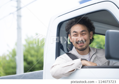 一名穿著工作服的中年男子駕駛一輛易於用於換工作和招聘的卡車,看著相機、運輸和送貨行業 一名穿著工作服的中年男子駕駛一輛易於用於換工作和招聘的卡車,看著相機、運輸和送貨行業 114073723