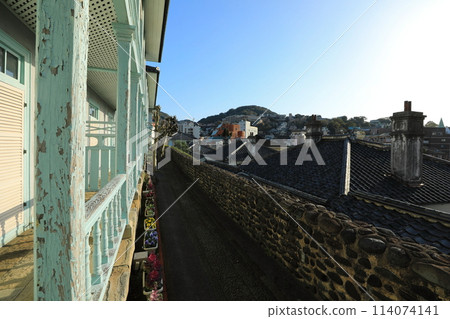 Under a clear sky, a view of the Higashiyamate Western-style houses facing Dutch Hill and the cityscape of Nagasaki (Nagasaki City, Nagasaki Prefecture, Japan) 114074141