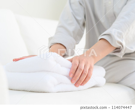 A woman who folds a towel 114074447
