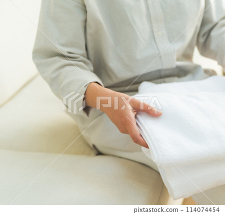 一個折疊毛巾的女人 114074454