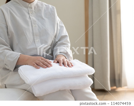 一個折疊毛巾的女人 114074459