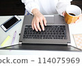 Woman's hands typing on a computer at home 114075969