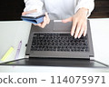 Woman's hands typing on a computer at home 114075971