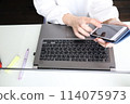 Woman's hands typing on a computer at home 114075973
