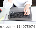 Woman's hands typing on a computer at home 114075974