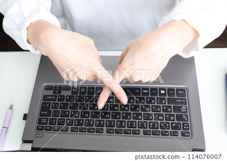 一位女士在電腦前用手指畫十字 一位女士在電腦前用手指畫十字 114076007