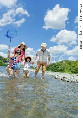 A family of four playing on a river in summer 114076053