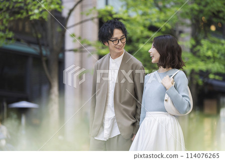 Smiling men and women in their 30s walking down the street 114076265