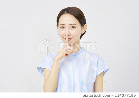 Middle-aged woman making a secret gesture on white background Middle-aged woman making a secret gesture on white background 114077199