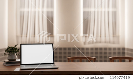 A close-up image of a laptop white screen mockup on a wooden table in a cozy Scandinavian room. 114077419