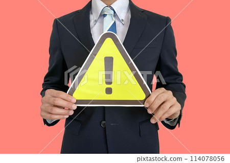 Salaryman holding a warning sign in front of him Salaryman holding a warning sign in front of him 114078056