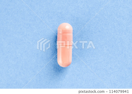 Pink two-piece hard starch capsule on blue background with copy space. Medical and Health concept. 114079941