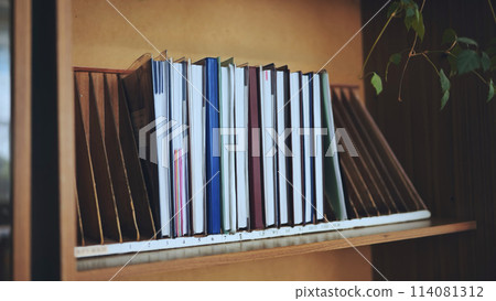 The teacher takes a school teacher's magazine from the shelf. The teacher takes a school teacher's magazine from the shelf. 114081312
