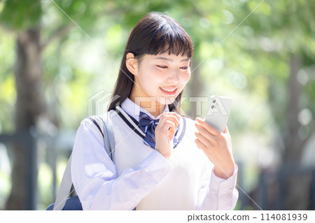 戴著耳機看著智慧型手機的高中女孩 114081939