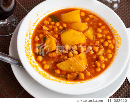 Stew boiled soup prepare of cod fillet, potatoes, chickpeas in tomato sauce. 114082610