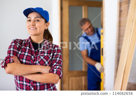Portrait of a young Latin female smiling at camera with crossed hands on chest during renovation at home Portrait of a young Latin female smiling at camera with crossed hands on chest during renovation at home 114082656