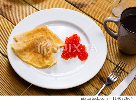 On plate - ruddy soft pancakes with spoonful fresh-grain caviar 114082664