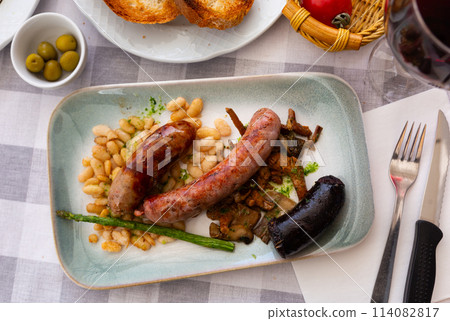 Catalan dish with baked sausages, fried beans, mushrooms and asparagus 114082817