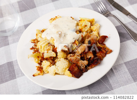 Plate of tasty boiled cauliflower with fried lard and sauce 114082822