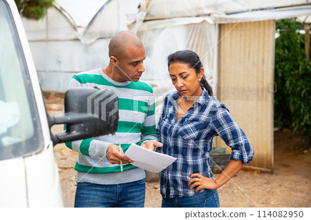 Farmer and freight forwarder sign documents for shipment in the courtyard Farmer and freight forwarder sign documents for shipment in the courtyard 114082950