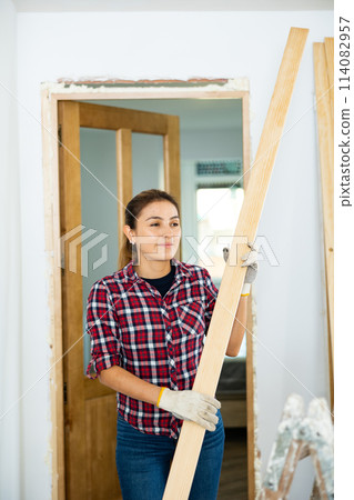 Woman prepares place to install door in doorway Woman prepares place to install door in doorway 114082957