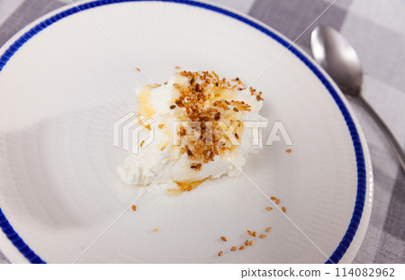 Homemade hearty breakfast - cottage cheese with honey sauce. dish is richly decorated with sesame 114082962