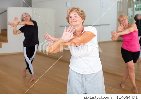 Mature active women practice vigorous swing 114084471