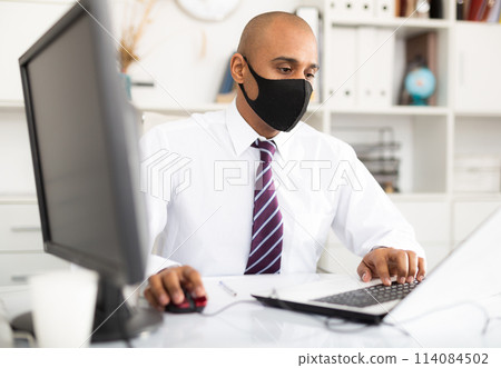 Business man wearing mouth protection to prevent getting sick at work in office Business man wearing mouth protection to prevent getting sick at work in office 114084502