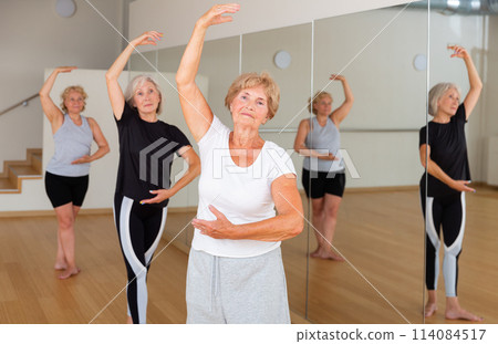 Senior lady learning classic dance moves during group class Senior lady learning classic dance moves during group class 114084517